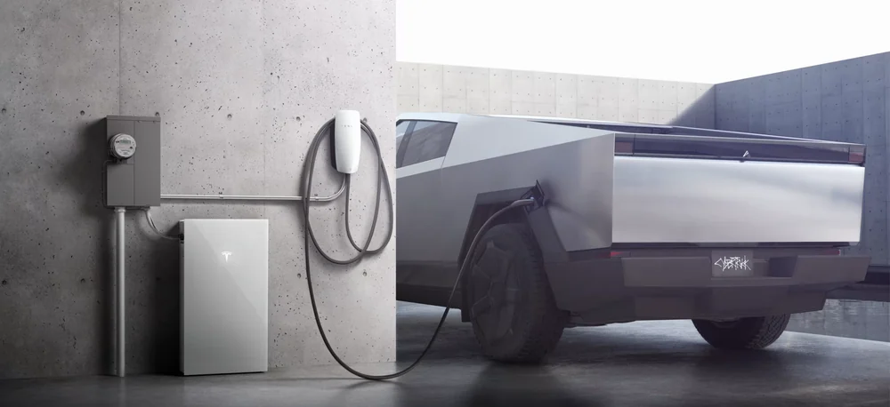Cybertruck connected to a Tesla Wall Connector beside home backup equipment