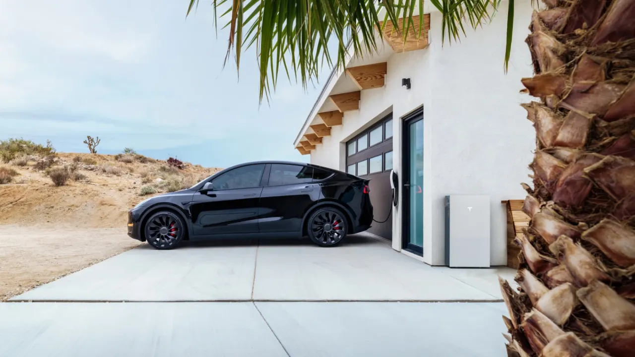 Electric vehicle parked beside a home with a Powerwall 3